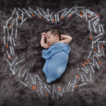 baby on the ground in a blue blanket